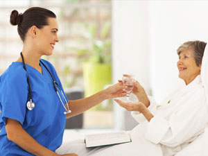 La enfermera entregando agua al paciente.